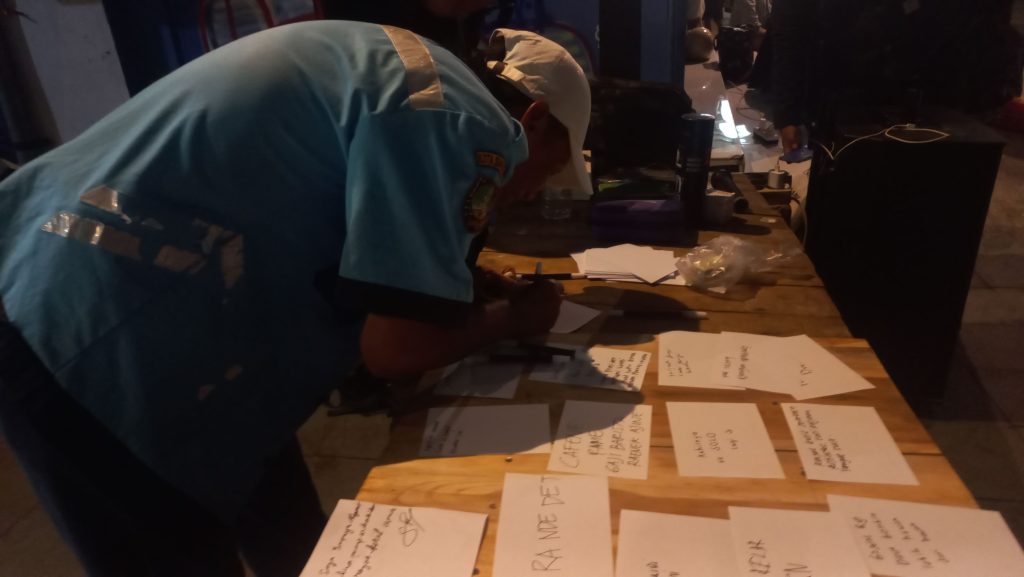 Seorang pengunjung menuliskan keluh kesah pada lembar kertas yang disediakan oleh panitia Festival Sambat, Surakarta, Senin (27/7). LPM Motivasi/Syiva Alifah